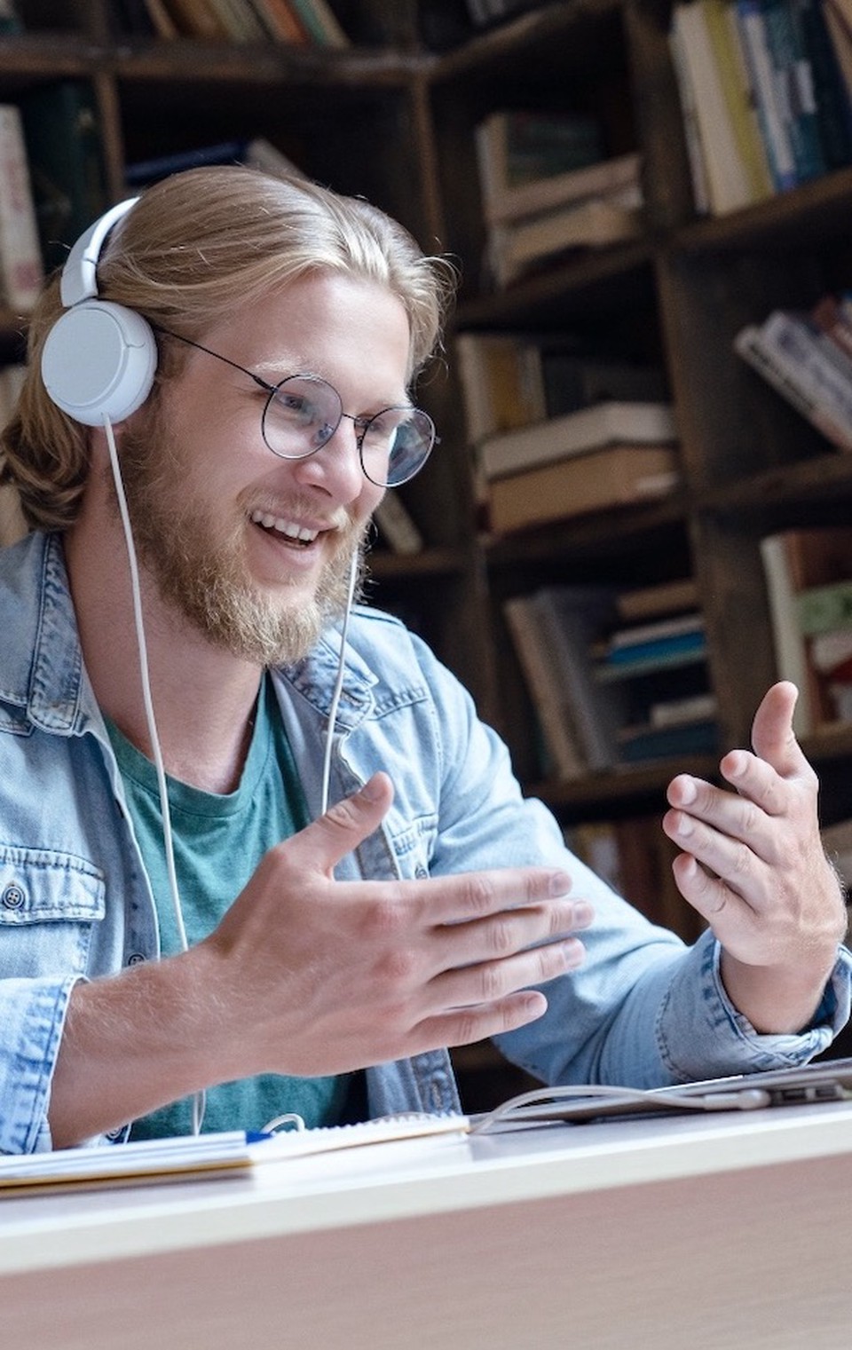 A man with headphones looking to a laptop screen