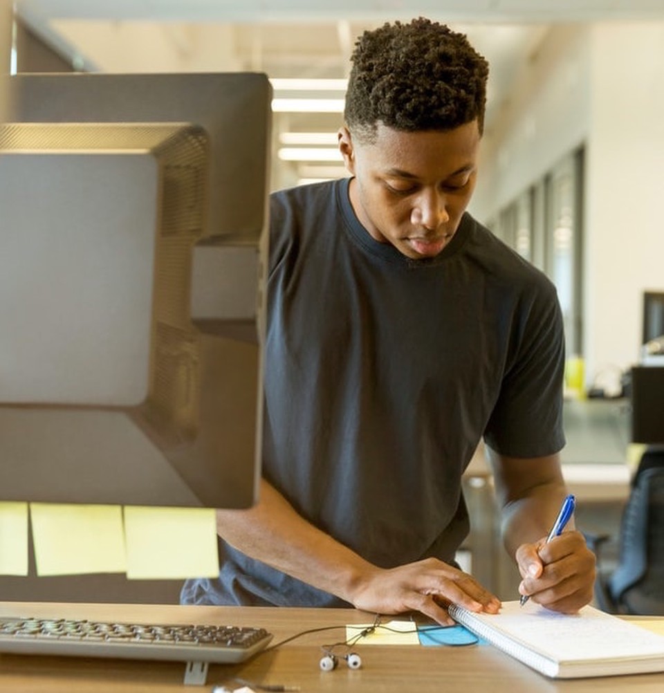 A man writing something on his notebook